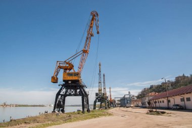 Açık güneşli bir günde Nehirdeki sanayi turnaları yükleme deposunu boşaltıyor