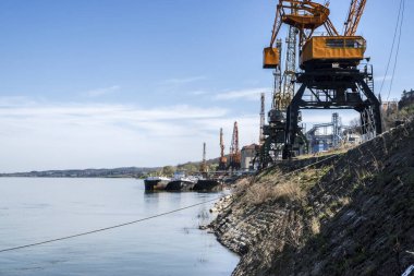 Açık güneşli bir günde Nehirdeki sanayi turnaları yükleme deposunu boşaltıyor