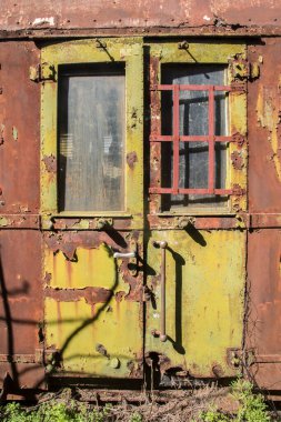 Terk edilmiş demiryolu vagonunun paslı ve soyulmuş boya duvarı renkli grunge arka plan olarak yakın plan