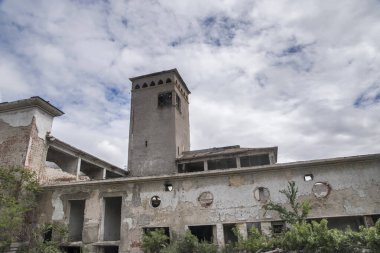 Terk edilmiş, yıkılan eski, modası geçmiş sanayi binası güneşli bir günde kapanıyor.