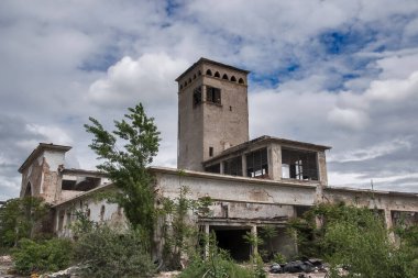 Terk edilmiş, yıkılan eski, modası geçmiş sanayi binası güneşli bir günde kapanıyor.