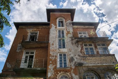 Güneşli bir günde eski, bakımsız ve harap bir köy evi.