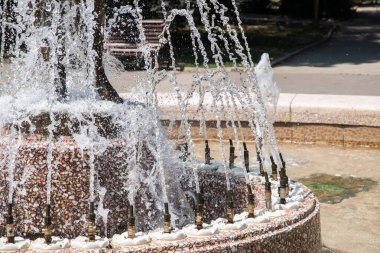 Güneşli yaz gününde şehir parkındaki çeşmeden köpüklü su.