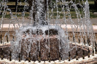 Güneşli yaz gününde şehir parkındaki çeşmeden köpüklü su.
