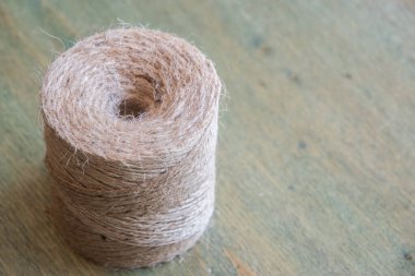 Doğal jüt sicim sarmalı ahşap arka planda sarılı.