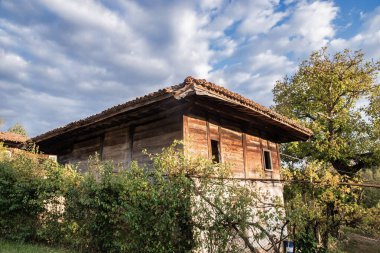 Kırsal kesimdeki eski ahşap ev güneşli bir günde, gün batımında
