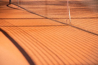 Tenis kortunda kırmızı kil kumda gölgeler var. Spor geçmişi.