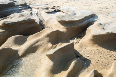 Güneşli yaz gününde kumsalda sakin deniz sularında aşınmış güzel bir taş.