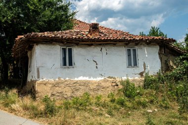Yıkılan duvarları ve yaşlanmış kırmızı kiremitli çatısı olan eski bir Balkan köyü evi