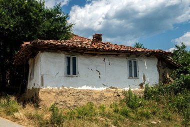 Yıkılan duvarları ve yaşlanmış kırmızı kiremitli çatısı olan eski bir Balkan köyü evi