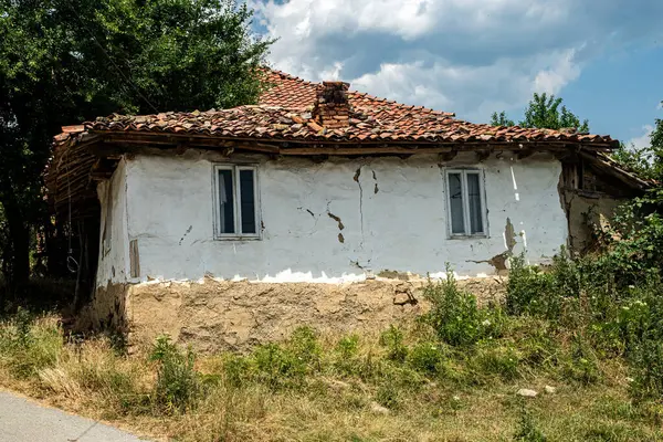 Yıkılan duvarları ve yaşlanmış kırmızı kiremitli çatısı olan eski bir Balkan köyü evi