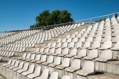 Beyaz plastik stadyum sıra sıra yıpranmış sandalye koltukları