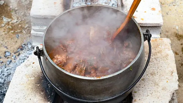 Yakacak odun yemeği hazırlayan çocuk Peru And yemeği. Ateşin üstünde yemek. Taş fırının arka planında odun pişiren demir tencereler.
