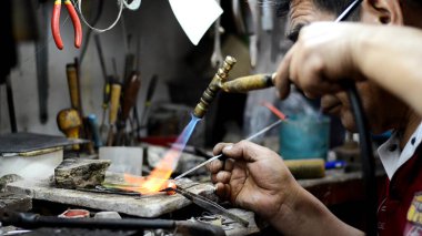 Ana kuyumcu bir süsleme takı atölyesinde kaynak. Eller ve ürün görüntü yakın çekim.