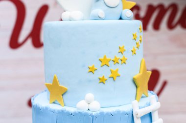 Close-up of a blue fondant cake decorated with yellow stars and white accents for celebrations clipart