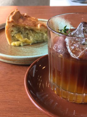 Tahta bir masada nefis bir dilim turtanın yanında serinletici bir buzlu kahvenin manzarası.