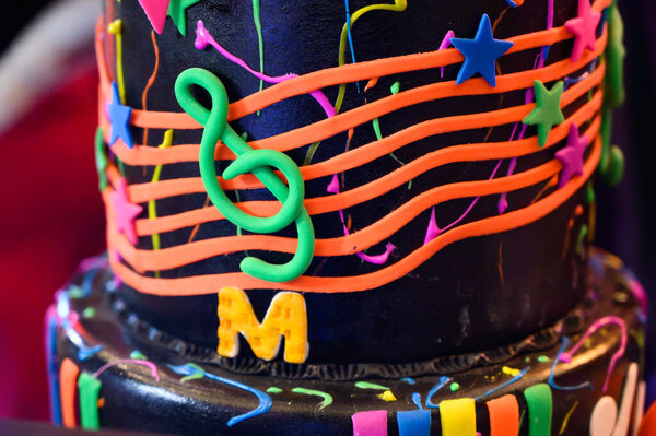 Close-up of a vibrant birthday cake decorated with musical notes and stars