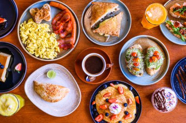 Ahşap bir yüzeye yerleştirilmiş çeşitli kahvaltı yemeklerinin genel görünümü