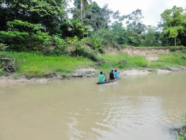 Iquitos Peru 'da Amazon nehrinde geleneksel kanoyla gezen yerli halk