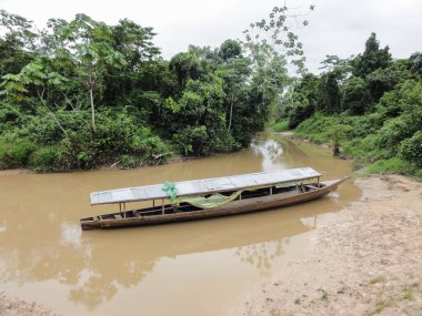 Çatısı olan uzun ahşap tekne iquitos, Peru 'daki Amazon nehrinin bulanık sularına demirlemiş.