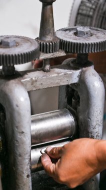 Goldsmith mücevher yapmak için metal şekillendirmek için bir değirmen kullanıyor.