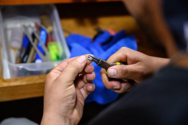 Goldsmith atölyesinde bir parça mücevher yapmak için kerpeten kullanıyor.