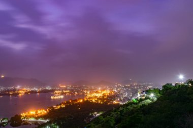 Udaipur şehir sarayı, Hindistan 'da güzel bir mor gökyüzü ile geceyi aydınlatıyor.