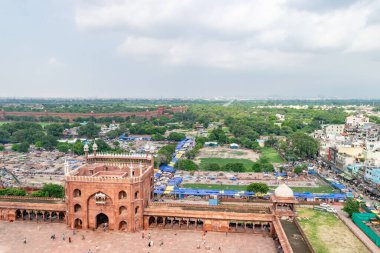 Hindistan 'ın Delhi kentindeki jama camisini gezen turistler, uzaktaki kırmızı kaleyi görüyorlar.