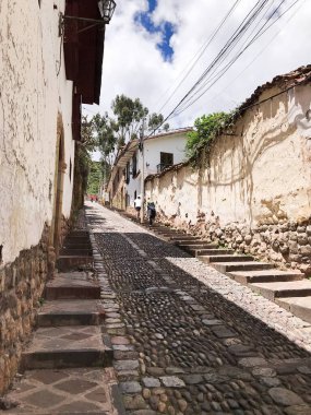 Geleneksel kaldırım taşı caddesi tarihi cusco, peru şehrinde yokuş yukarı, antik inka mimarisini gözler önüne seriyor.