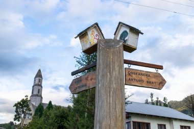 Şili 'deki costanera arturo prat ve katedralin yönünü gösteren yıpranmış ahşap tabela.