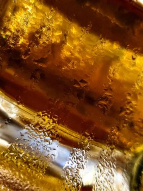 Soğuk ve ferahlatıcı bir içeceğin büyüleyici yakın çekim görüntüsü, zengin renklerde güzel bir yoğunlaşma sergiliyor.