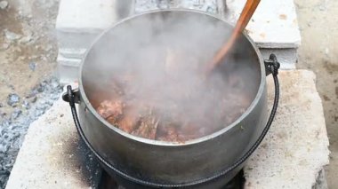 Yakacak odun yemeği hazırlayan çocuk Peru And yemeği. Ateşin üstünde yemek. Taş fırının arka planında odun pişiren demir tencereler..