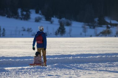 Weissensee, Avusturya - 8 Şubat 2022: Weissensee Gölü (Avusturya) Kışın güneşli bir günde insanlar buz pateni yapıyor