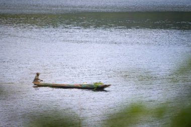 Kabale, Uganda - 12 Haziran 2022: Bunyonyi Gölü 'nde (Uganda) bir kanodaki adam, yazın güneşli bir gün