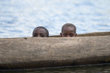 Kabale, Uganda - 12 Haziran 2022: Bunyonyi Gölü 'ndeki bir kanoda çocuklar (Uganda), yazın güneşli bir gün