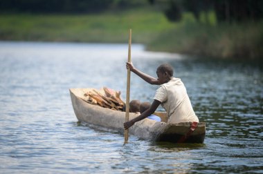 Kabale, Uganda - 12 Haziran 2022: Bunyonyi Gölü 'ndeki bir kanoda çocuklar (Uganda), yazın güneşli bir gün