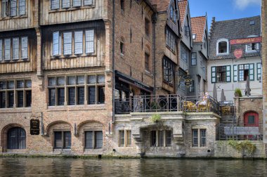 Bruges, Belgium - July 4, 2022: Old houses at a canal in Bruges, daylight, reflection