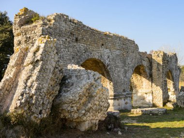Baharda güneşli bir günde Arles yakınlarında barbekü su kemeri ve değirmenleri. Bu Roma kompleksi bir su kemeri ve iki paralel sekiz kişilik yamaçtan inen 16 su tekerleğinden oluşuyordu. (Provence, Fransa)