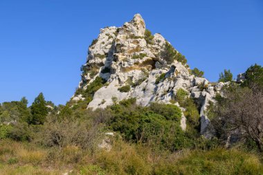 Les Baux de Provence (Fransa) yakınlarında açık bir baharda mavi gökyüzü ile büyük bir kaya oluşumu