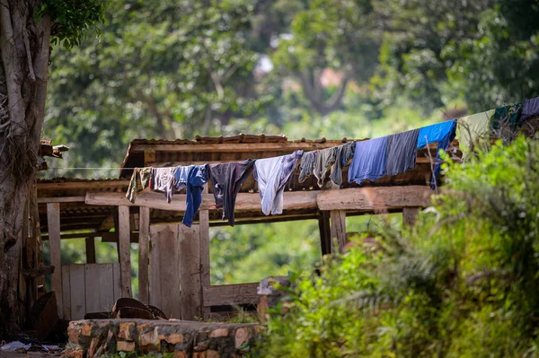 青い服を着た東アフリカの木製小屋の前にある小さな服のライン — ストック写真