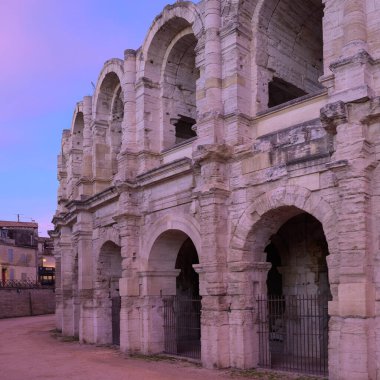 Arles, Fransa - 13 Mart 2023 Sabahın erken saatlerinde Arles Roma Arenası, güneşin doğuşu, pembe gökyüzü