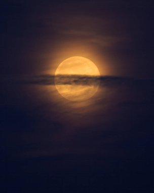 Kuzey Fransa 'da yazın bulutların arkasında sarı dolunay