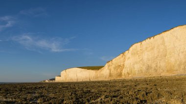 Yazın güneşli bir günde Ault yakınlarındaki sahil ve yüksek uçurumlar, mavi gökyüzü, alçak gelgit, kuzey Fransa