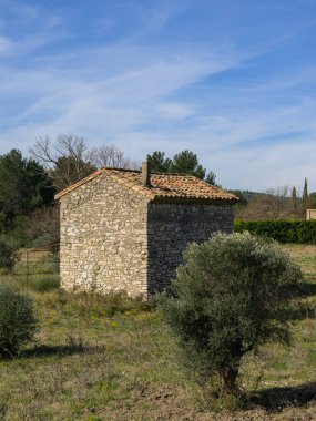 Baharda açık güneşli bir günde mavi gökyüzü ile Provence (Fransa) 'da taştan yapılmış küçük bir kulübe