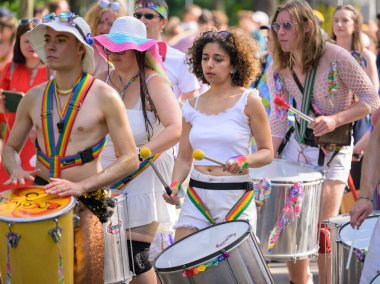 Viyana, Avusturya - 17 Haziran 2023: Yazın Viyana Gururu 'nda Wiener Ringstrasse' de insanlar, bir kadın yürüyor ve davul çalıyor