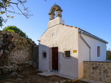 Cres 'te Pernat yakınlarında küçük bir kilise, sonbaharda güneşli bir gün, mavi gökyüzü.