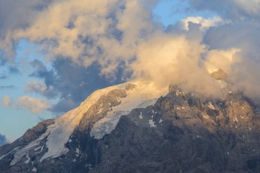 Ortler Alpleri, Stelvo Geçidi yakınlarında yazın günbatımında, tepenin etrafında bulutlar.