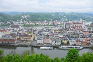 Passau, Germay - 15 Nisan 2024: Veste Oberhaus 'tan Passau şehrinin sakin ve bulutlu bir günde Tuna Nehri ve Hanı manzarası