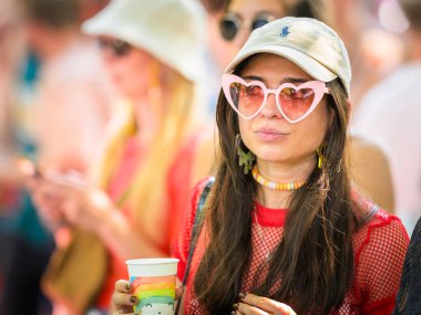 Viyana, Avusturya - Haziran 08, 2024: Yazın Viyana Gururu 'nda Wiener Ringstrasse, kalp şeklinde güneş gözlüğü takan kadın