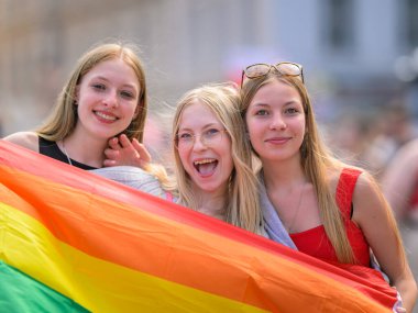 Viyana, Avusturya - Haziran 08, 2024: Yazın Viyana Gururu 'nda Wiener Ringstrasse' de insanlar, gökkuşağı bayrağı taşıyan kızlar